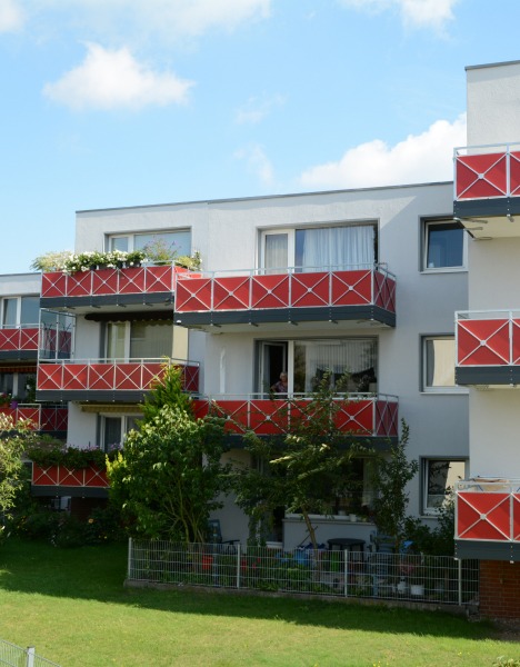 Balkone_Referenz_2 Rote Balkone mit Edelstahlrahmen an einem Wohnkomplex.