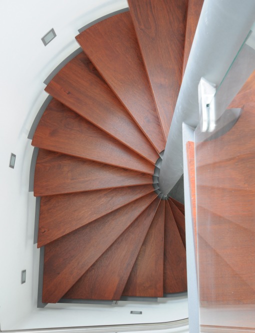 Wendeltreppe-12 Eine Wendeltreppe aus Metall in Kombination mit elegantem rotstichigem Holz