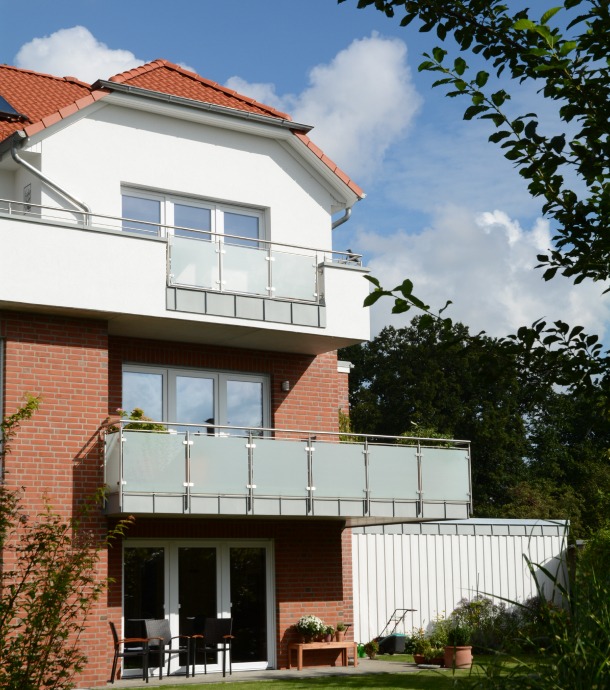 Ein moderner Balkon, umfasst von einem Geländer aus Metall und Glas